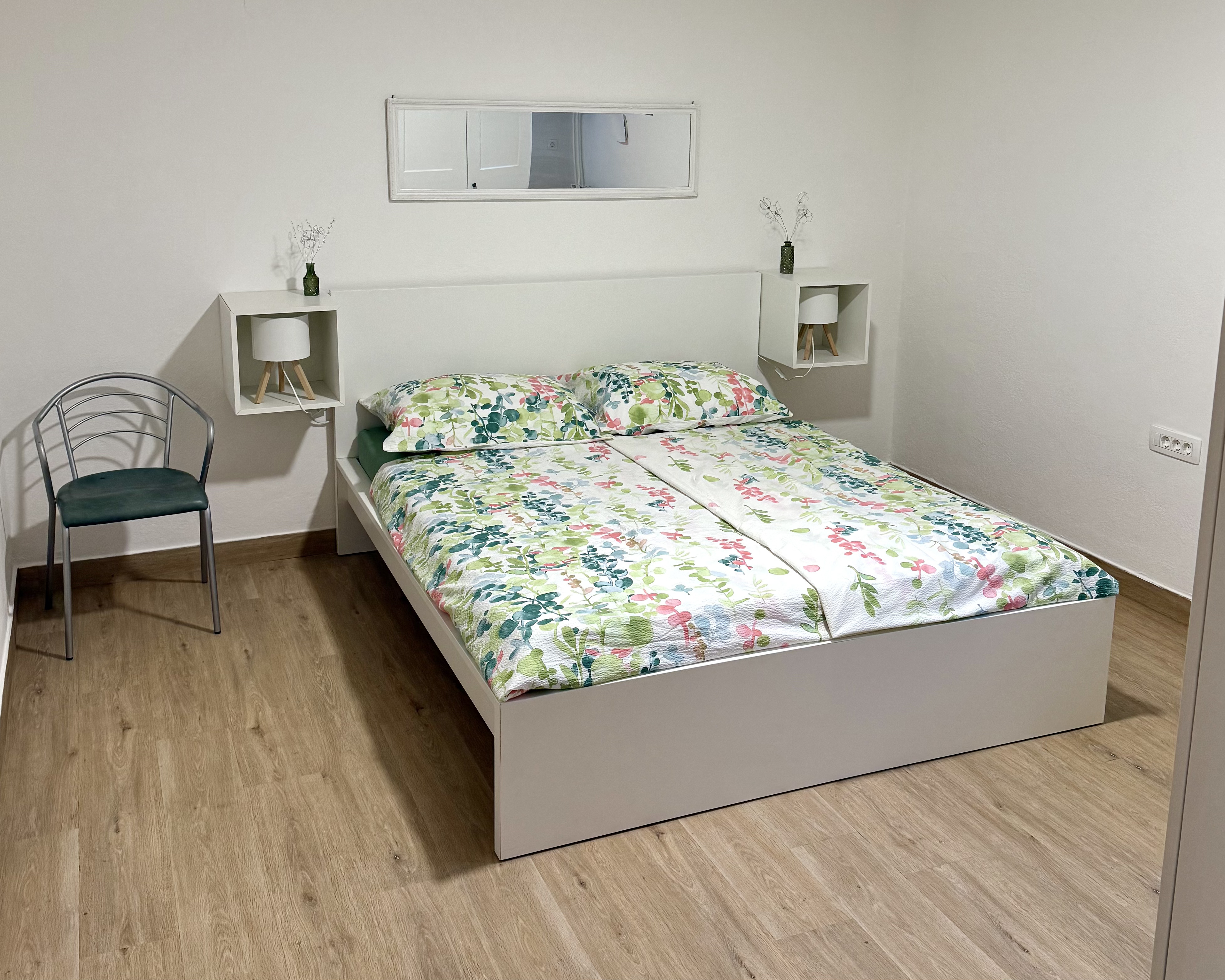 Master bedroom at Apartma Pija — styled with floral linen and warm natural light