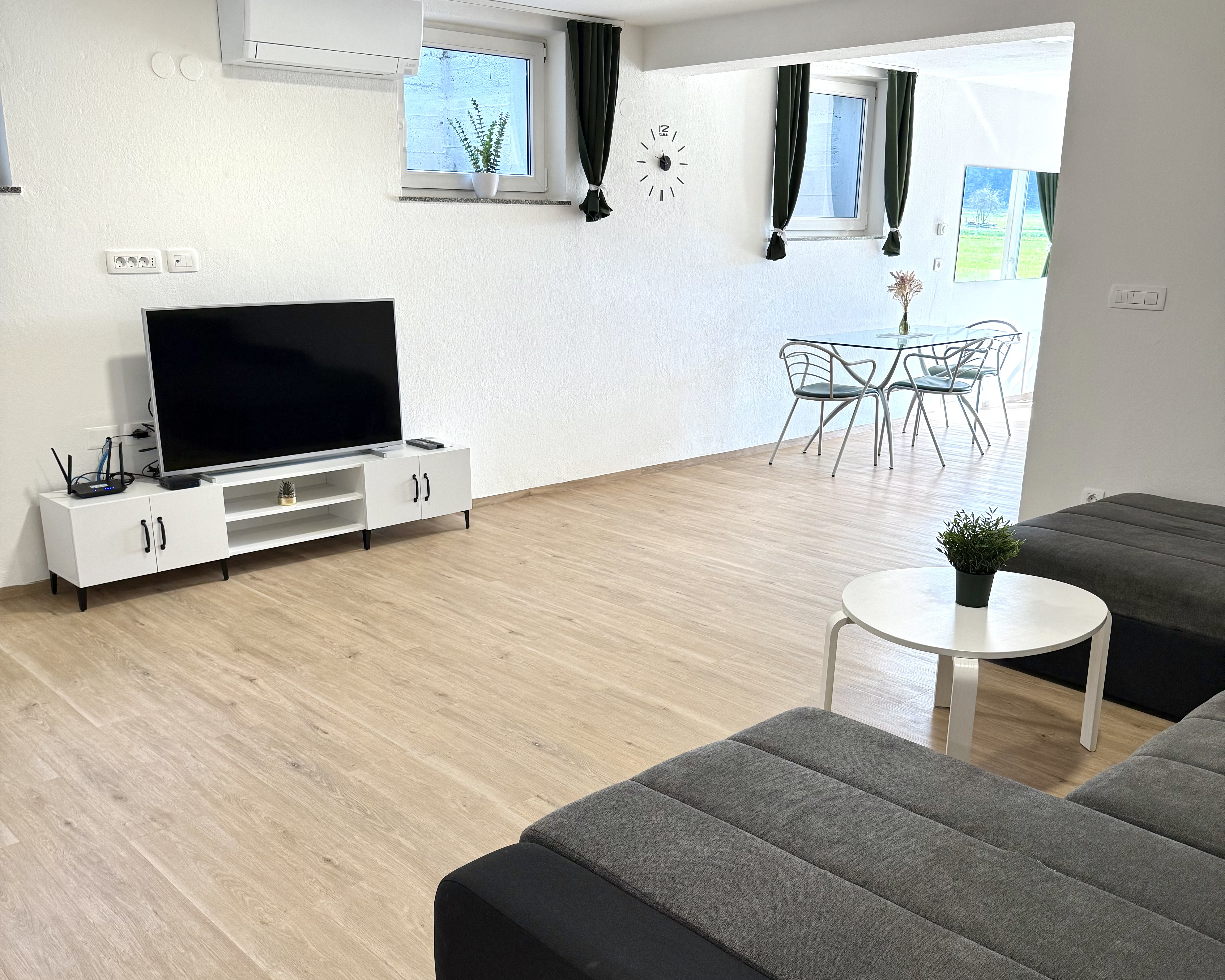 Spacious living room with corner sofa, smart TV and dining area