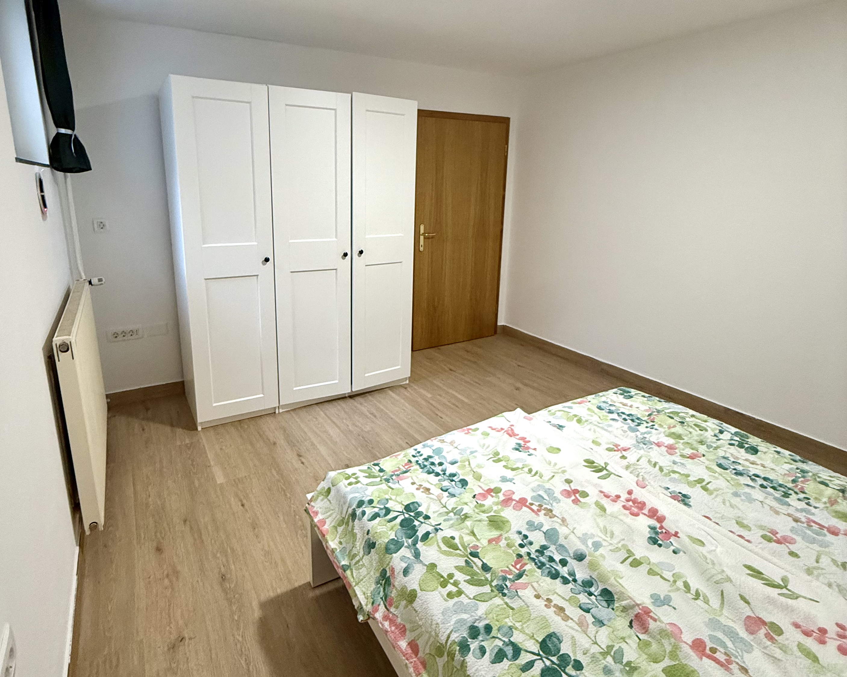 Bedroom with double bed, floral linen and built-in wardrobe